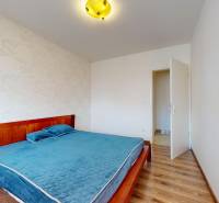Bedroom in a 4-room apartment with patterned wallpaper, a double bed, and wooden flooring.