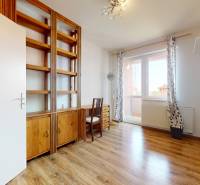 Room in a 4-room apartment with wooden floors, a bookshelf, and a desk.