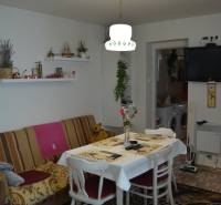 Dining room with a couch, table, TV, and decorations in a family house.