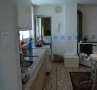 A kitchen in a family house with wooden cabinets, a sink, and a stove.