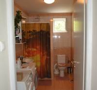 Bathroom in a family house with a washing machine and toilet.