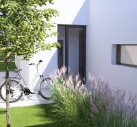 A family house in Gaboltov with a lawn, a bicycle, and ornamental grasses by the wall.