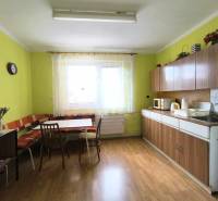 A kitchen in a family house with a table, chairs, kitchen unit, and a window.