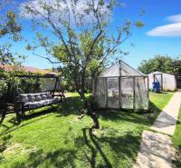 The garden of a family house in Partizánske - Malé Bielice area, on the street, with a swing and greenhouses.