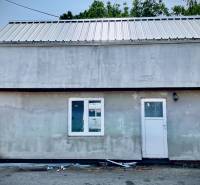 A cottage in Cífer with a metal roof, double window, and white door.