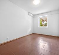 A room with white walls and brown tiles in the villa.