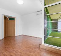 An empty room in a villa, with a wooden floor and a large window to the terrace.