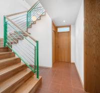 Staircase and doors in the interior of a villa with terracotta tiles and wooden paneling.