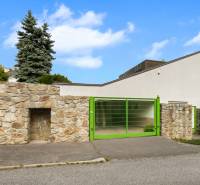 A villa on Čremchová Street in Bratislava - Koliba with a stone fence and a green gate.