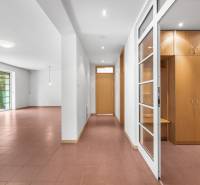 The interior of the villa with a spacious hall, white walls, and built-in wooden cabinets.