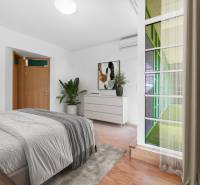 Bedroom in a family house with a bed, wardrobe, and decoration, wooden floor.