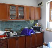 A kitchen in a family house with wooden cabinets and appliances on the countertop.