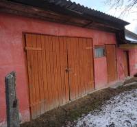 The exterior of a family house in Telkibanya with a wooden gate and a snow cover.