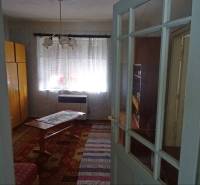 Interior of a family house with wooden furniture, a table, and a decorative carpet.