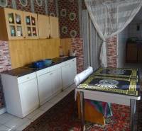A kitchen in a family house with colorful walls, cabinets, and a decorative black countertop.
