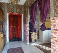 Interior of a family house with curtains, a cabinet, and decorative walls.