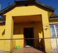 A family house in Vilmany with a yellow facade and a smaller concrete entrance area.