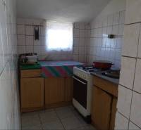 A kitchen in a family house with a gas stove and tiled walls.