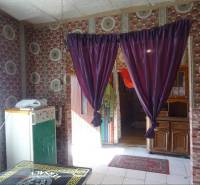 The interior of a family house with striking wallpaper, curtains, and wooden furniture.