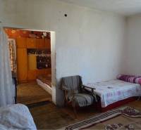 A simple room in a family house with beds and a carpet.