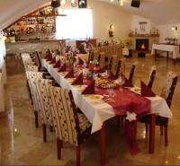A restaurant room with a table set for a feast, decorated in hotel style.