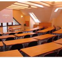 Conference room with wooden tables and chairs within hotels and guesthouses.
