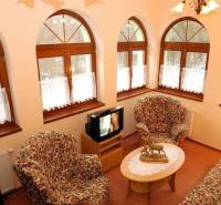 Interiors of hotels and guesthouses with armchairs, a table, and a television.
