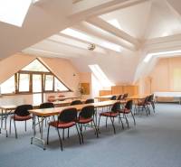 The interior of a conference room with windows, tables, and chairs in a hotel and guesthouse.
