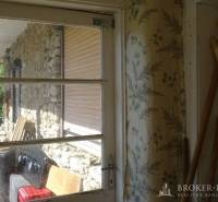 Interior of a family house with wallpapers and a view of stone walls in Pusztafalui.