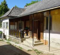 A family house in Pusztafalou with a veranda, garden, and stone foundation.
