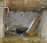 A tool shed in a family house with stone walls and a wooden ceiling.