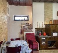 A kitchen with a traditional ceramic stove and a wooden ceiling in a family house.
