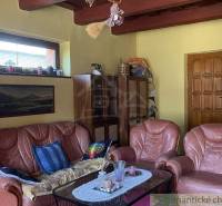Living room in a family house with brown leather furniture and wooden beams.