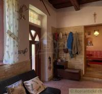 Interior of a family house with a wooden ceiling, coat rack, sofa, and decorations.