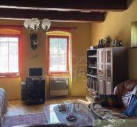 Living room in a family house with a leather sofa, display cabinet, and decorations.