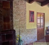 The interior of a family house with a tiled stove and floral decoration in the corner of the room.