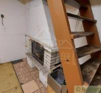 Wooden stairs next to the fireplace in the cottage kitchen.