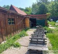 A wooden cabin near Myjava surrounded by greenery and simple seating made from pallets.