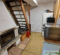 The cottage features a fireplace, a staircase, a kitchenette with a microwave, and a refrigerator.