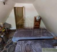 Attic room in a cottage with two beds and storage space.