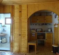 Interior of a family house with wooden cabinets and a view of the bathroom.