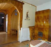 Interior of a family house with wooden paneling, ceramic tiles, and curtains.