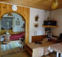 Interior of a family house with a sofa, wooden ceiling, and wall decorations.