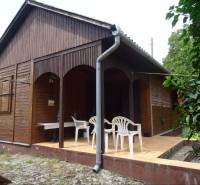 Wooden family house in Fony with a back terrace and plastic chairs.