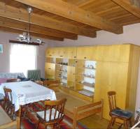 Wooden ceiling, older furniture, and dining table in a family house.