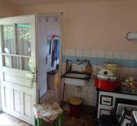 A family house kitchen with rustic equipment and older furniture.