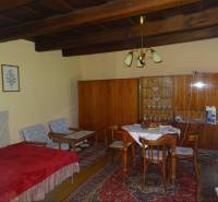 Wooden ceiling, furniture, dining table and chairs in a family house with a carpet.
