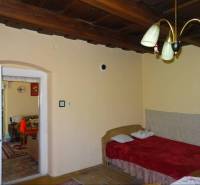 A room in a family house with a wooden ceiling, a sofa, and a chandelier in Mediterranean style.