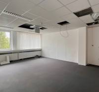 Empty office space with an open ceiling and a large window.