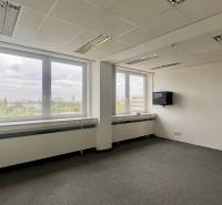 Offices with large windows and a view, simple furnishings, neutral interior.